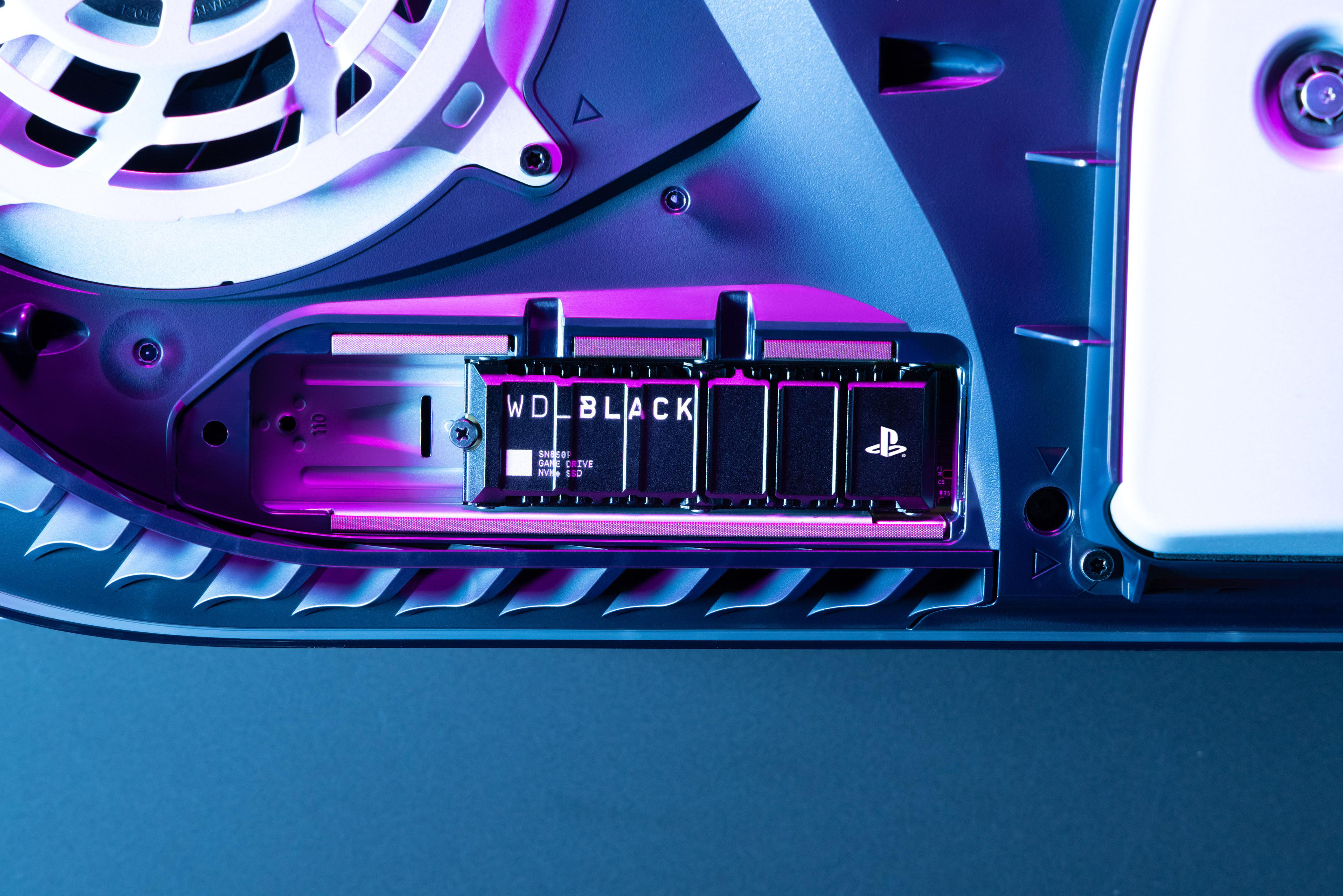 Geöffnete PlayStation 5 mit schwarzem Speichergerät, beschriftet mit 'WD BLACK'.