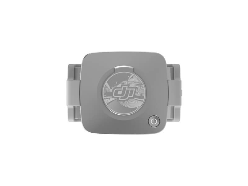 DJI drone kontrolcüsü, yukarıdan görünüm. Güç düğmesi ve DJI logosu ile gri. Temiz beyaz arka plan.