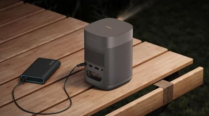 Projecteur, montrant la lumière. Le fond est sombre, sur une surface en bois.