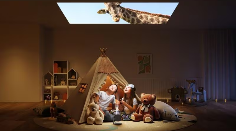 Enfants dans une tente regardant une girafe projetée au plafond.