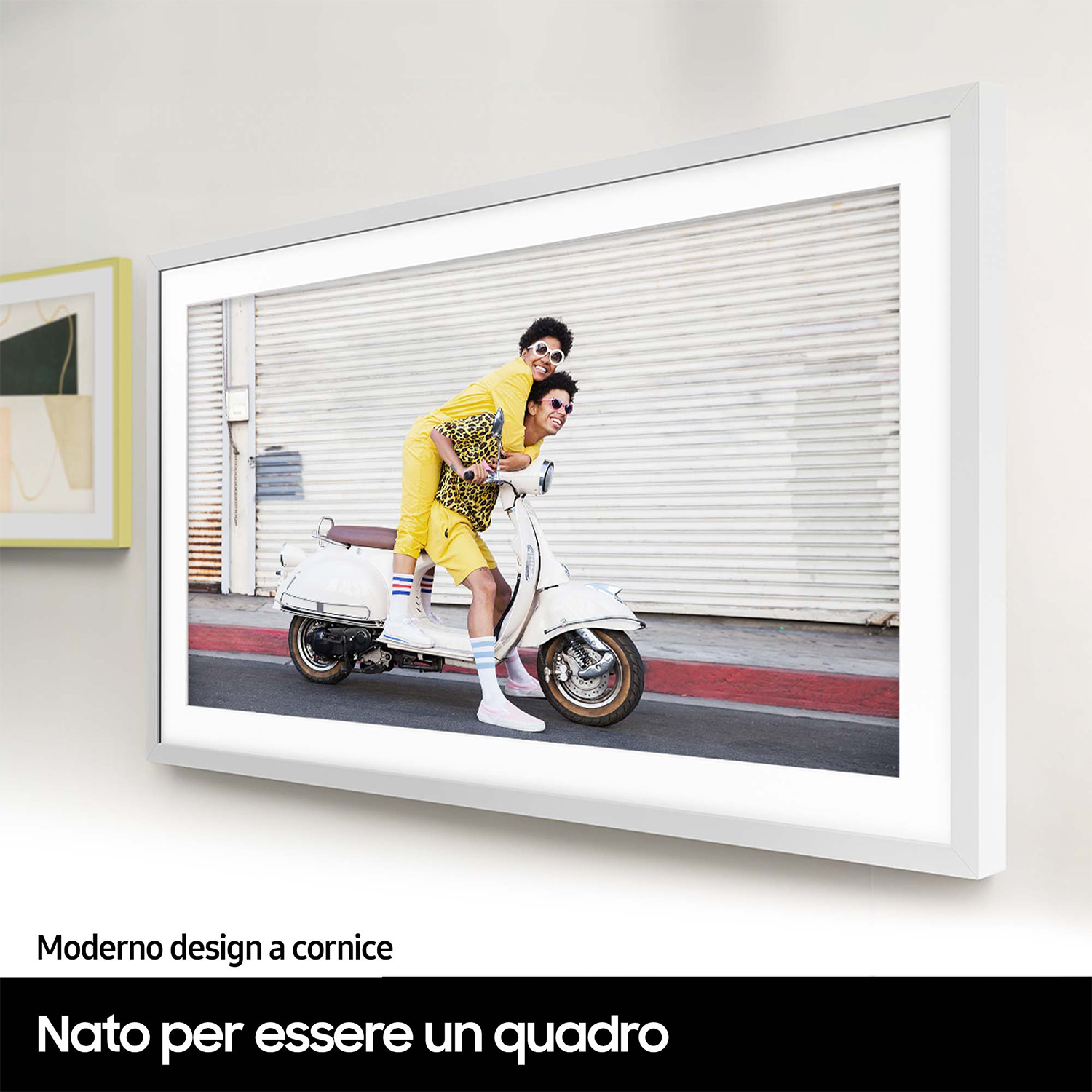 Una foto incorniciata di due persone su uno scooter. Stanno sorridendo. La cornice è bianca.