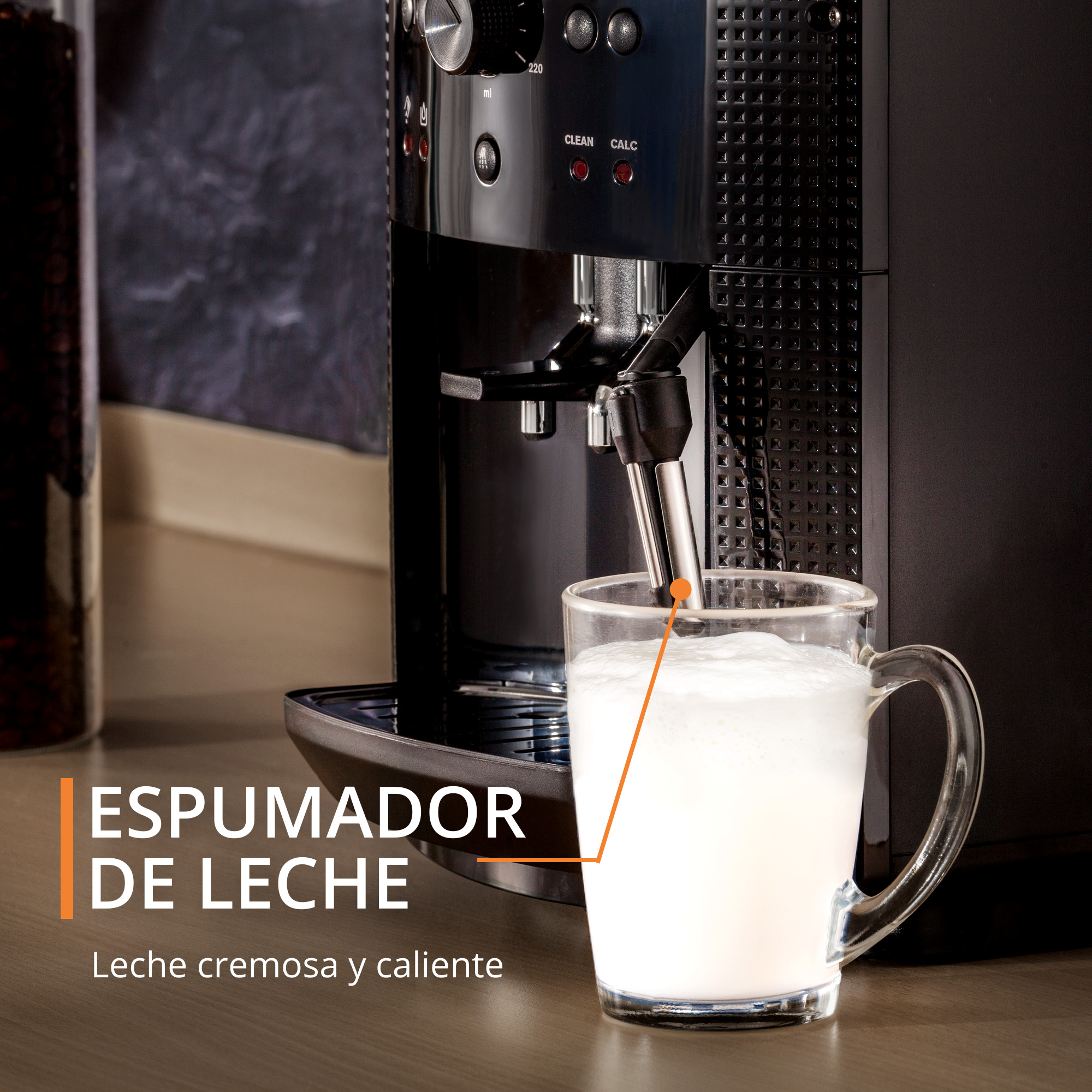 Máquina de café dispensando espuma de leche en una taza de vidrio. Texto: Espumador de leche, cremoso y caliente.