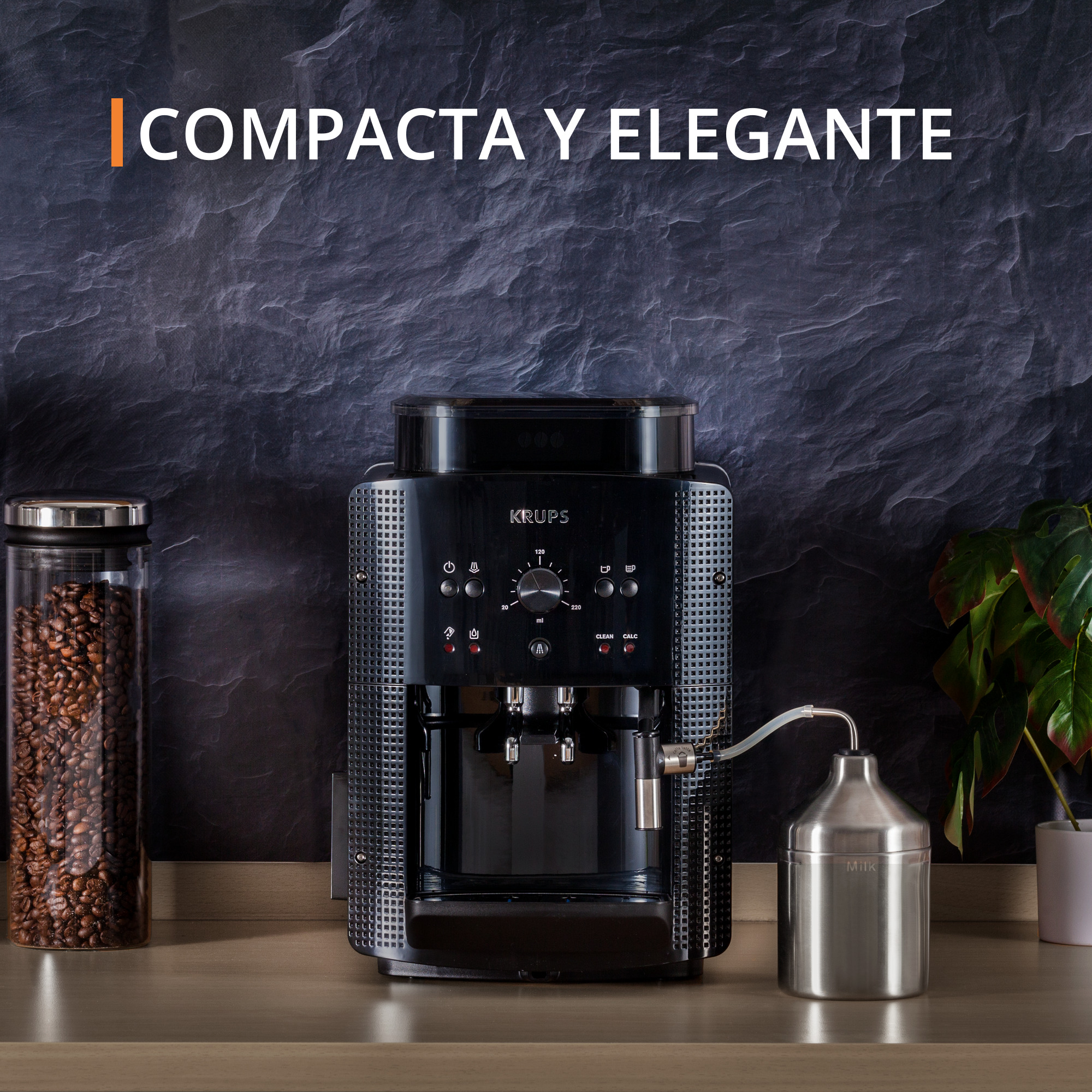 Una cafetera Krups negra con una jarra de leche y un tarro de granos de café sobre una superficie de madera.