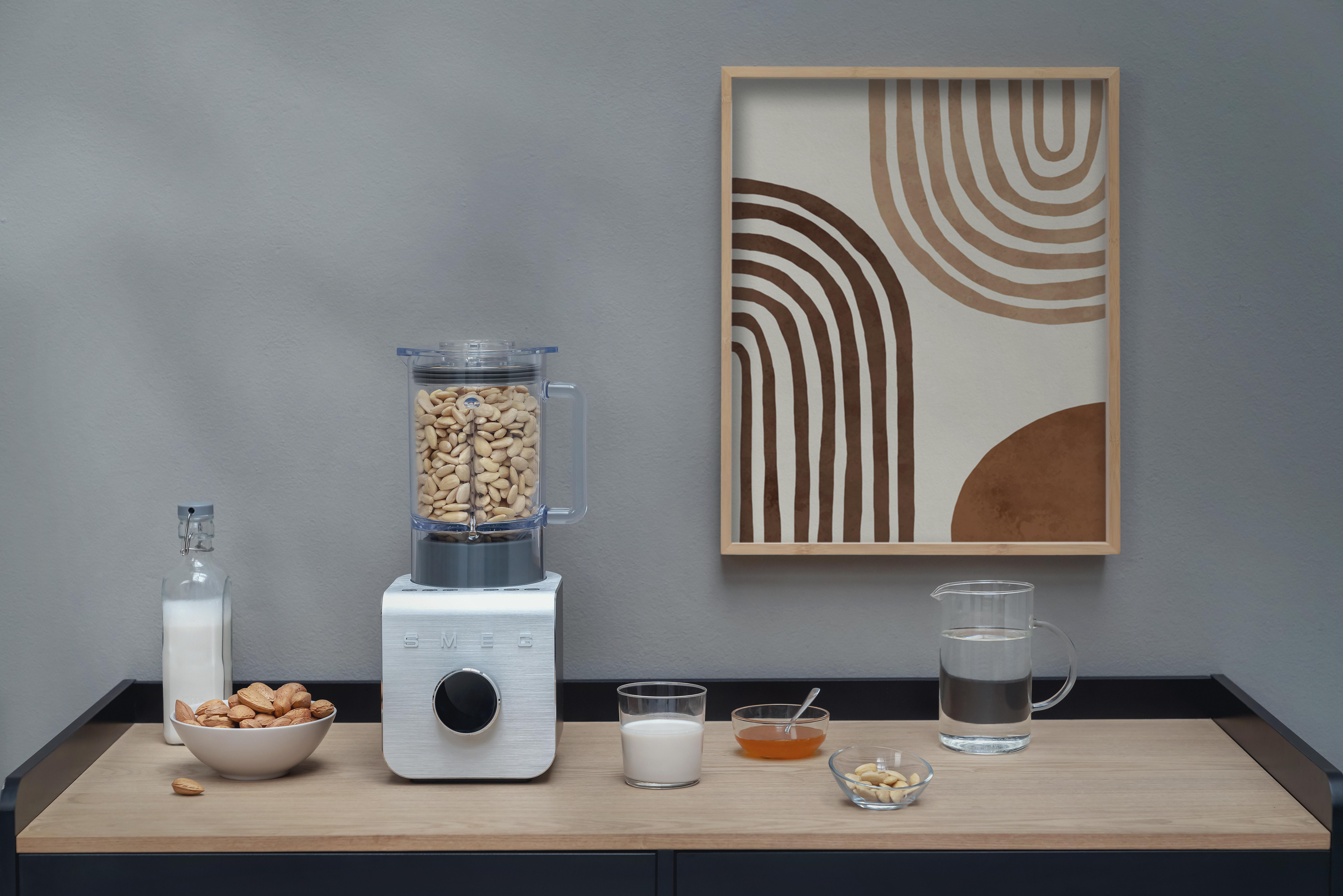 Mixer mit Nüssen, Milchflasche, Schüssel mit Mandeln und Kunst an der Wand.