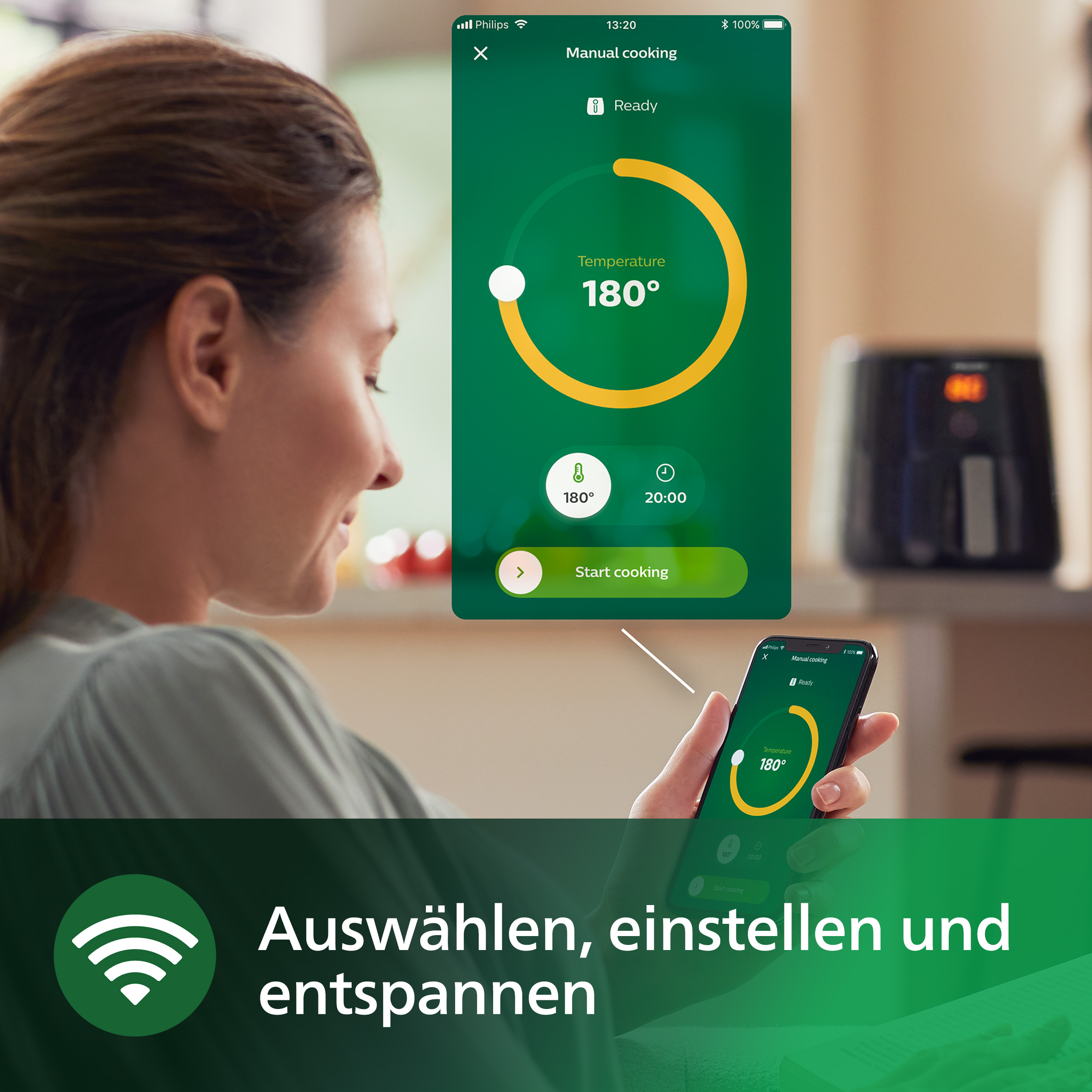 Eine Frau benutzt ein Telefon, um eine Heißluftfritteuse zu steuern. Das Telefon zeigt 180 Grad und 20 Minuten an.