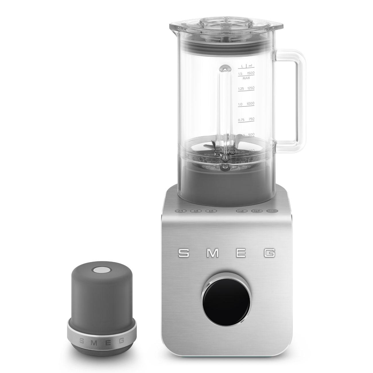 Ein silberner SMEG-Blender mit grauem Oberteil und separatem grauen Deckel. Ein Drehknopf ist sichtbar.