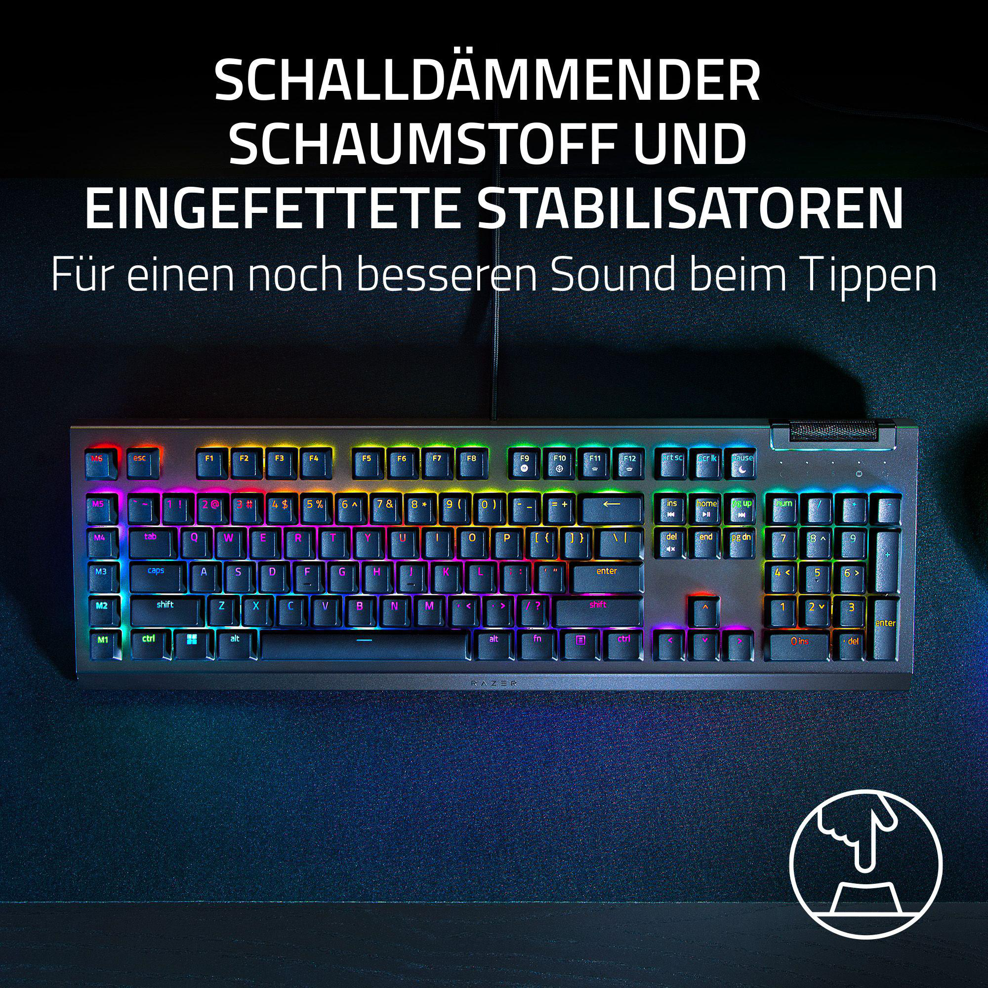 Nahaufnahme einer Tastatur mit bunten beleuchteten Tasten. Text auf Deutsch: schalldämmender Schaumstoff und Stabilisatoren.