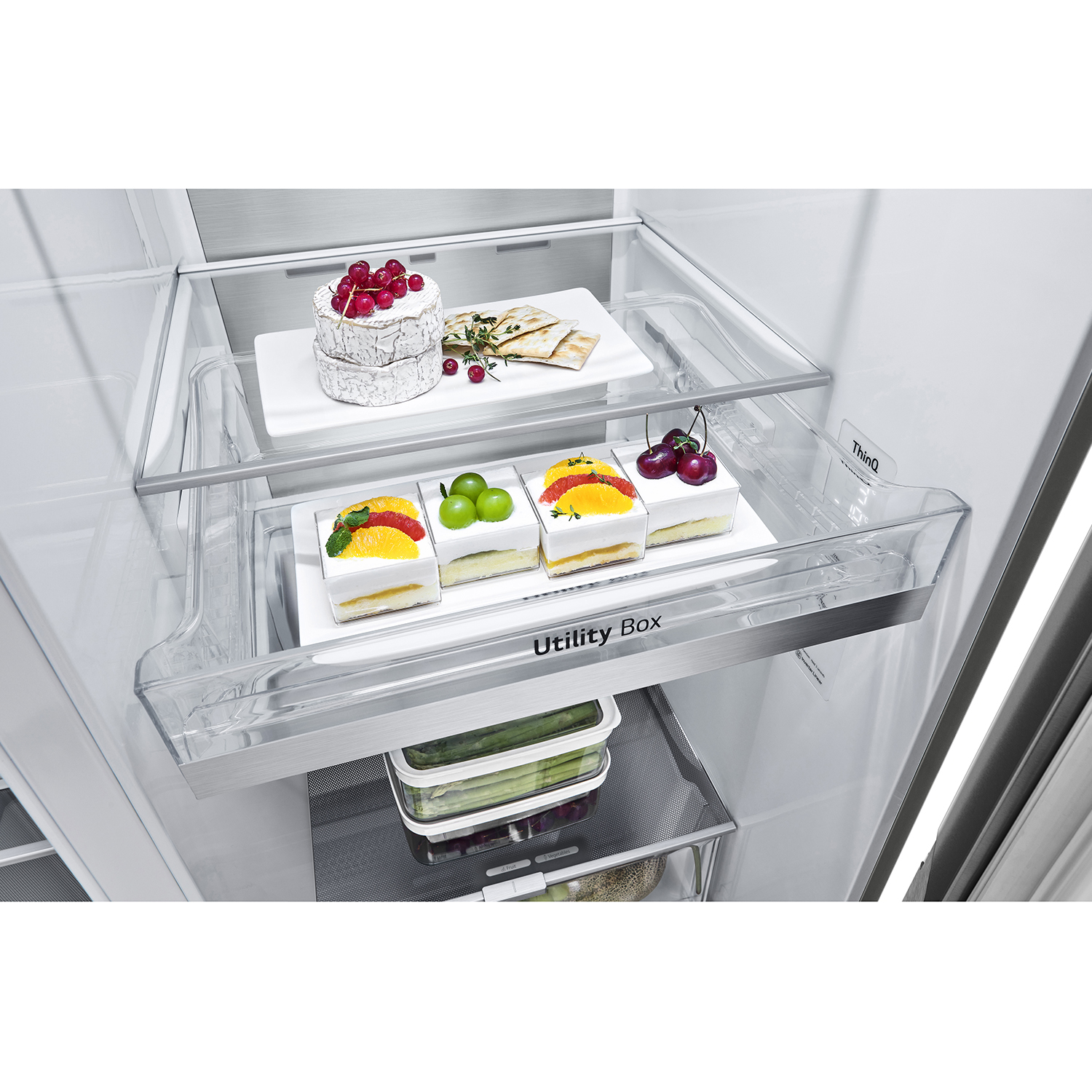 Interno del frigorifero con ripiani che contengono alimenti, tra cui torte, frutta e verdura.