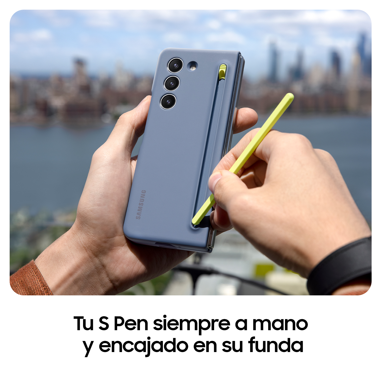 Manos sosteniendo un teléfono gris con un bolígrafo amarillo. El texto dice: 'Tu S Pen siempre a mano y encajado en su funda'.