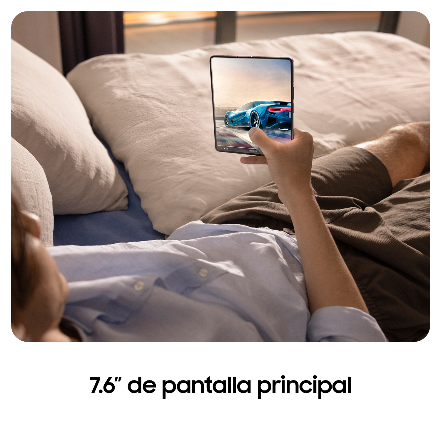 Persona acostada en una cama mirando una tableta, que tiene una imagen de un coche. La cama es blanca.