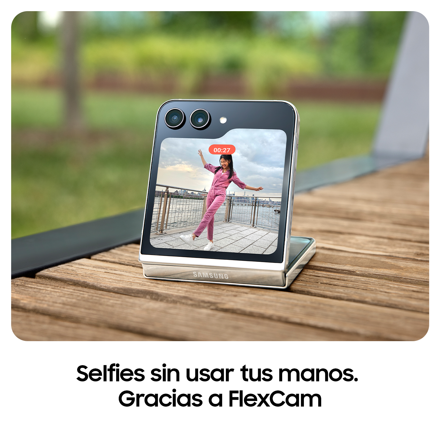Smartphone abierto, mostrando video de mujer, ambiente exterior, mesa de madera.