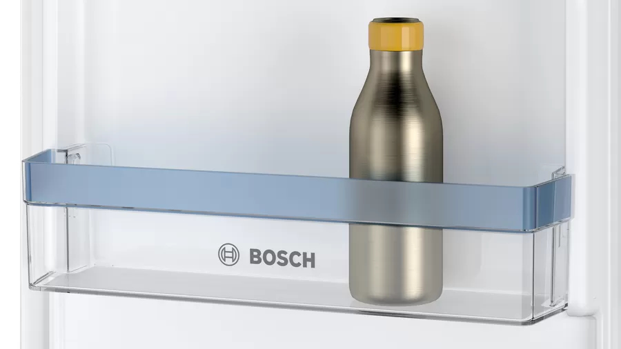 Estante de refrigerador con una botella plateada con tapa amarilla. El logotipo de Bosch es visible.
