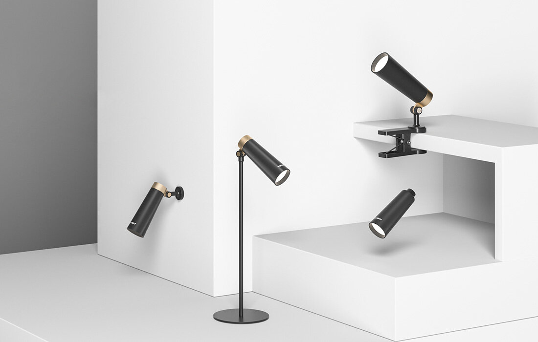 Cztery czarne reflektory w różnych układach. Białe tło, minimalistyczny styl.