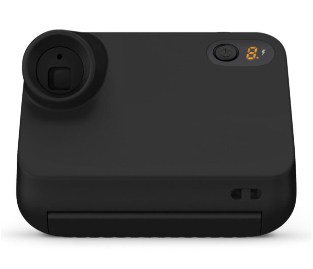 Czarny aparat natychmiastowy z zaokrąglonymi krawędziami. Posiada obiektyw, przycisk zasilania i wyświetlacz, wszystko na białym tle.