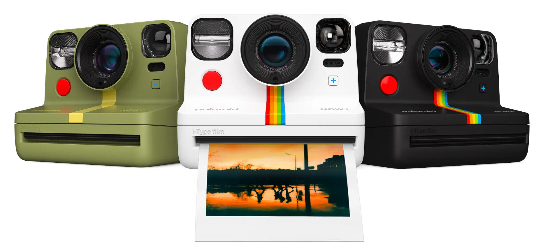 Trzy aparaty Polaroid w różnych kolorach, jeden z wysuwanym zdjęciem.