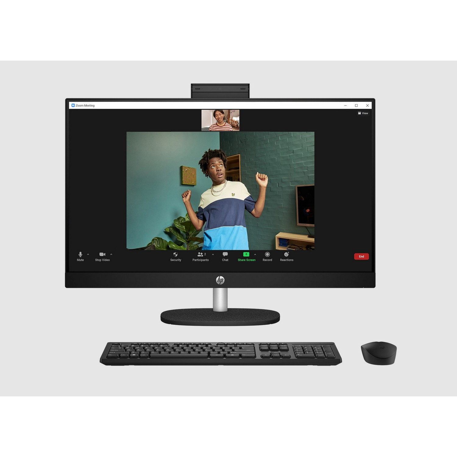 A computer monitor displays a video call. A keyboard and mouse are in the foreground.