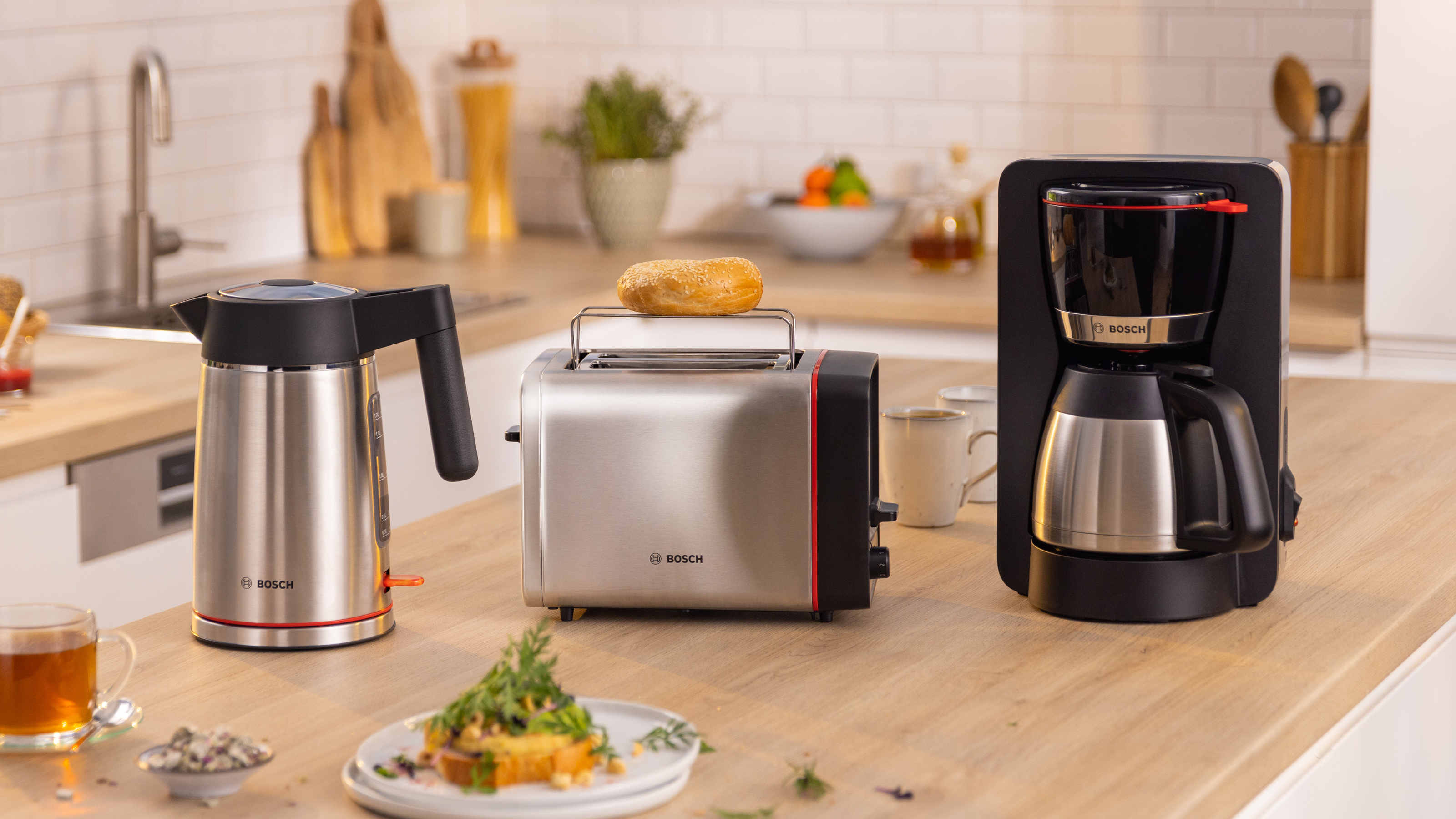 Küchengeräte: Wasserkocher, Toaster mit Bagel, Kaffeemaschine. Holztheke. Marke Bosch.