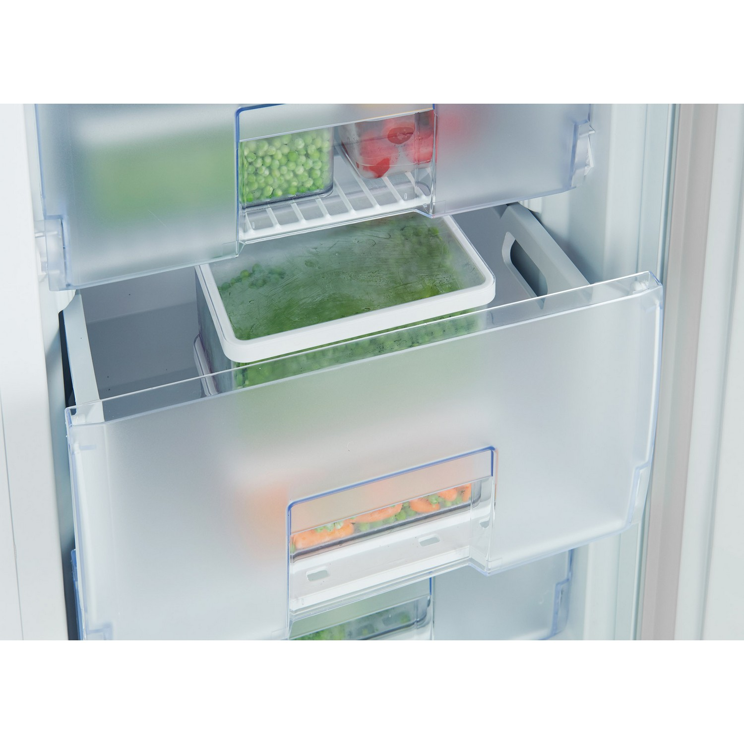 A refrigerator interior, showing drawers with various frozen vegetables and other items.