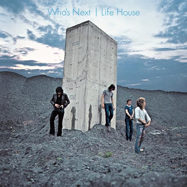Pochette de l'album Who's Next. Quatre hommes debout près d'une structure en béton sur un paysage rocheux sous un ciel nuageux.