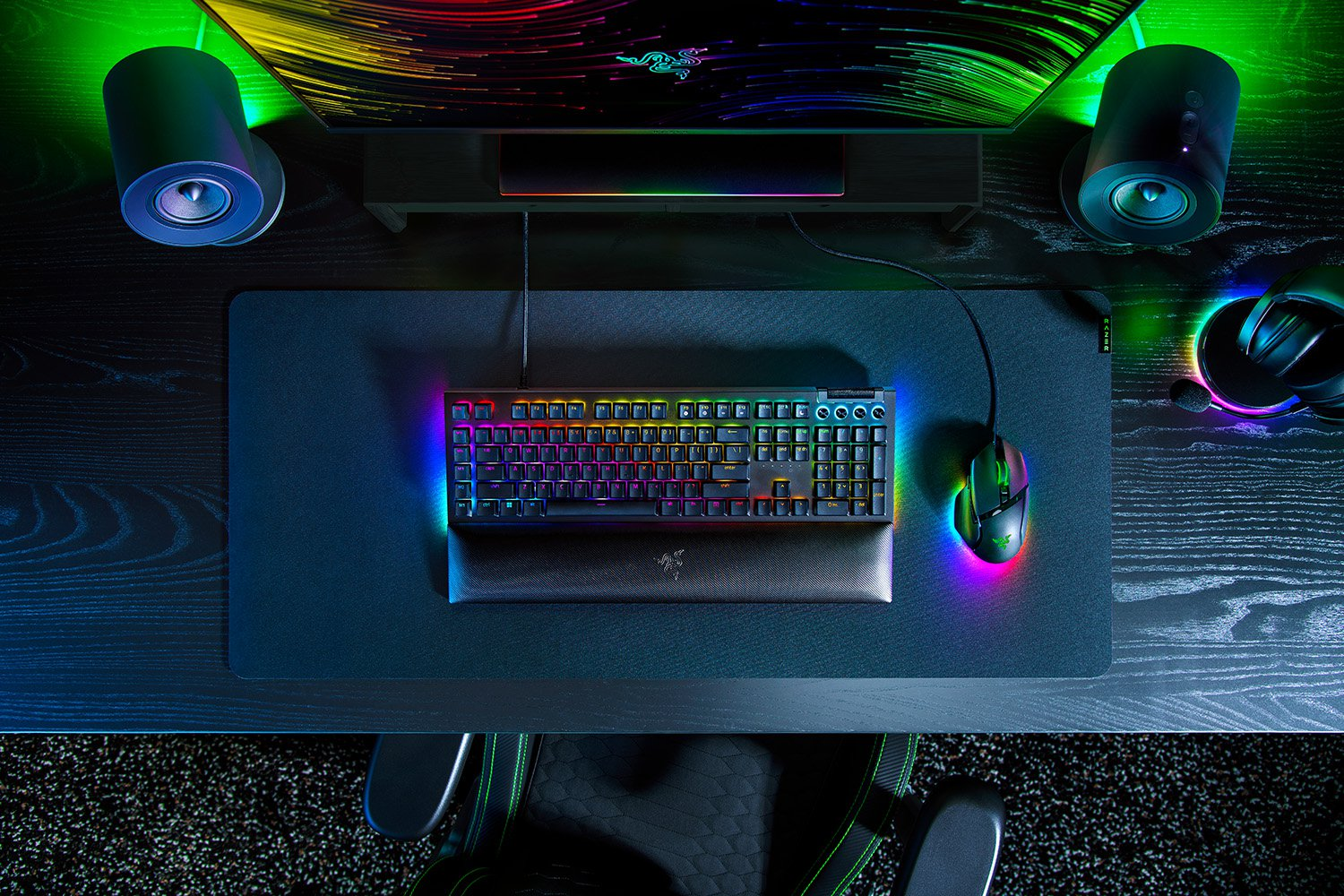 Configurazione gaming con tastiera, mouse, monitor, altoparlanti e cuffie.