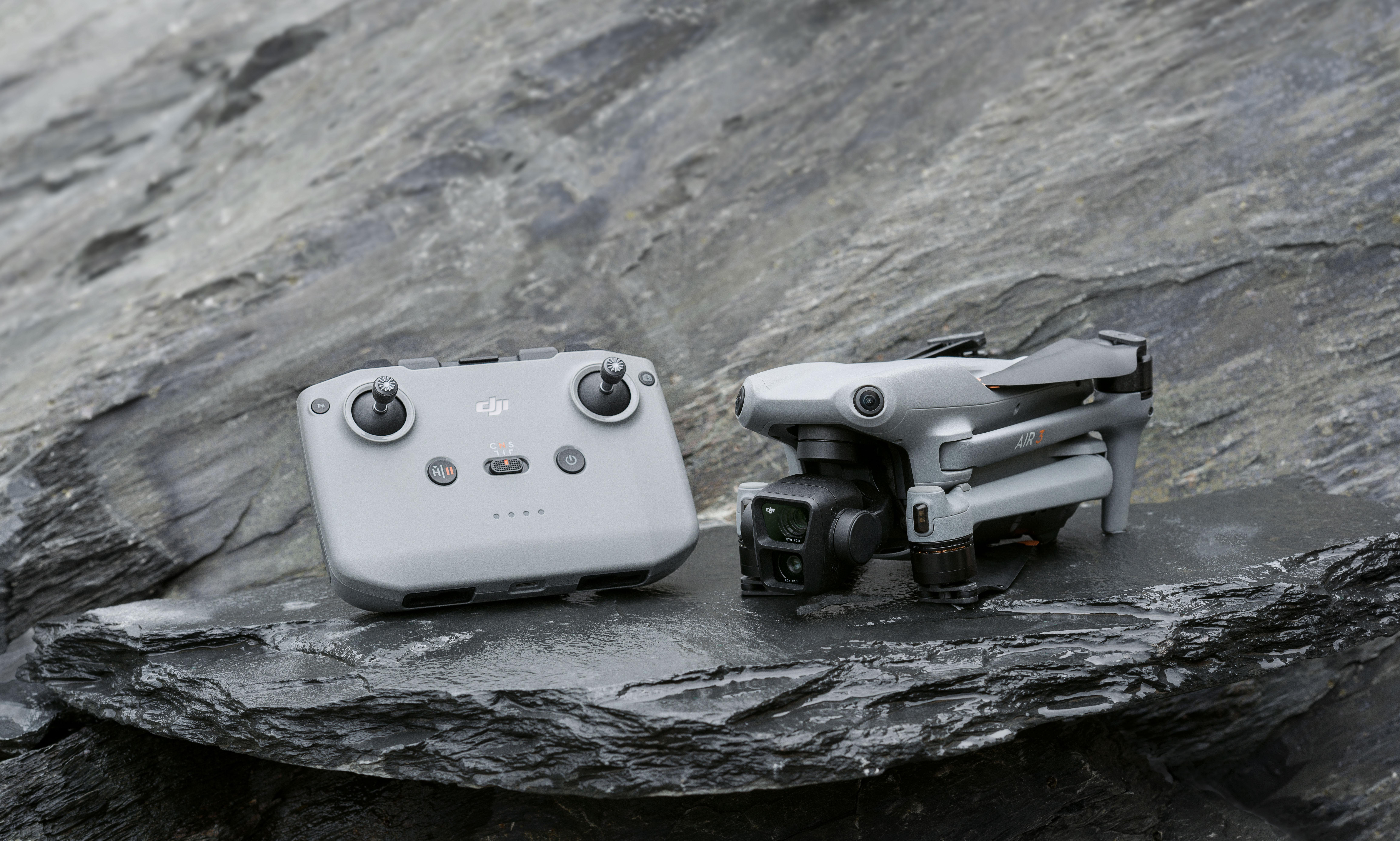 Eine schwarze Drohne mit grauem Controller auf einem Felsen.