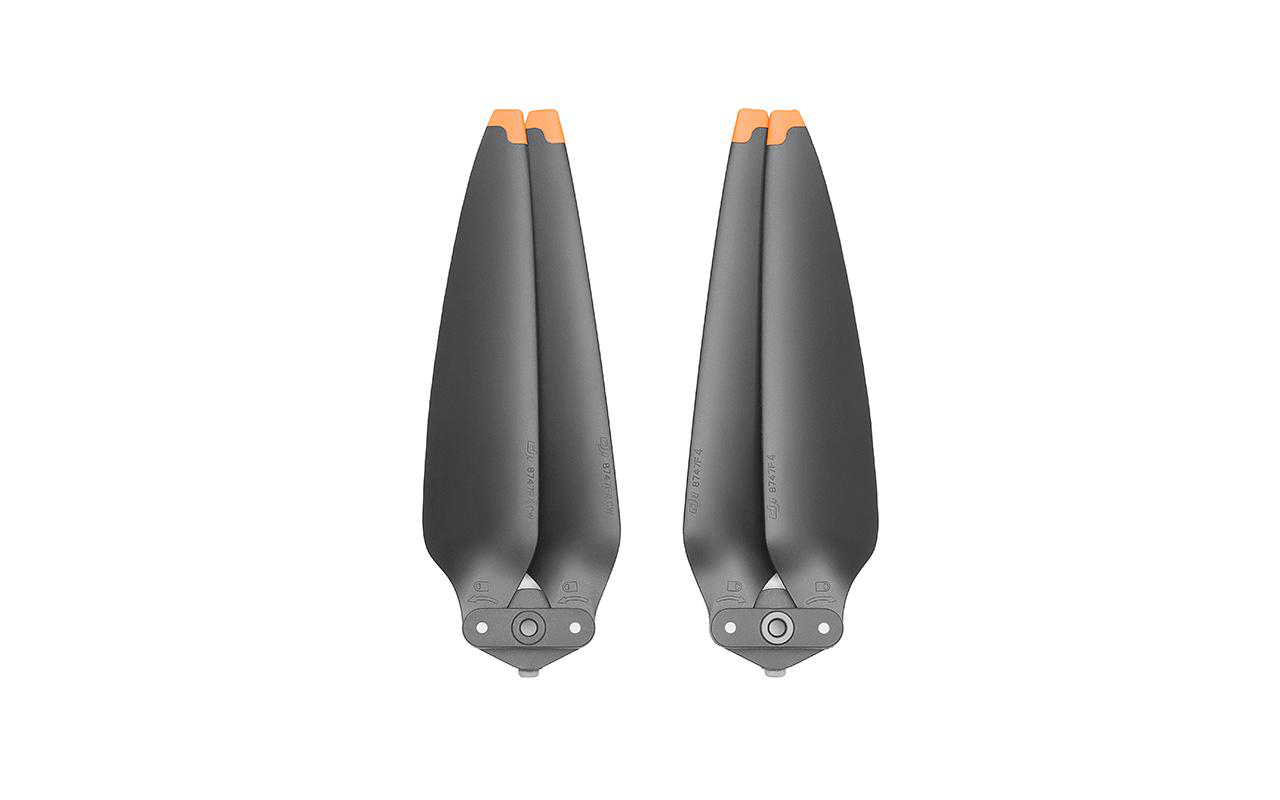 Zwei Drohnenpropeller. Sie sind grau mit orangen Spitzen, auf weißem Hintergrund.