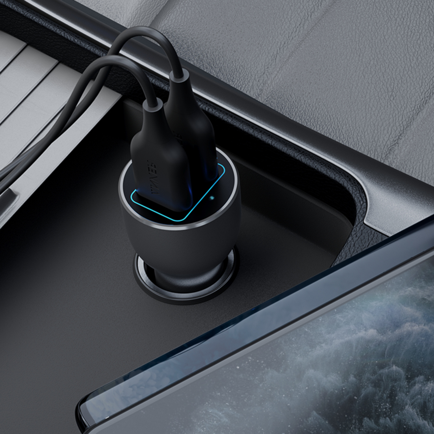Black car charger with two USB ports, with connected cords. A phone is partially visible in the foreground. The car interior is visible.