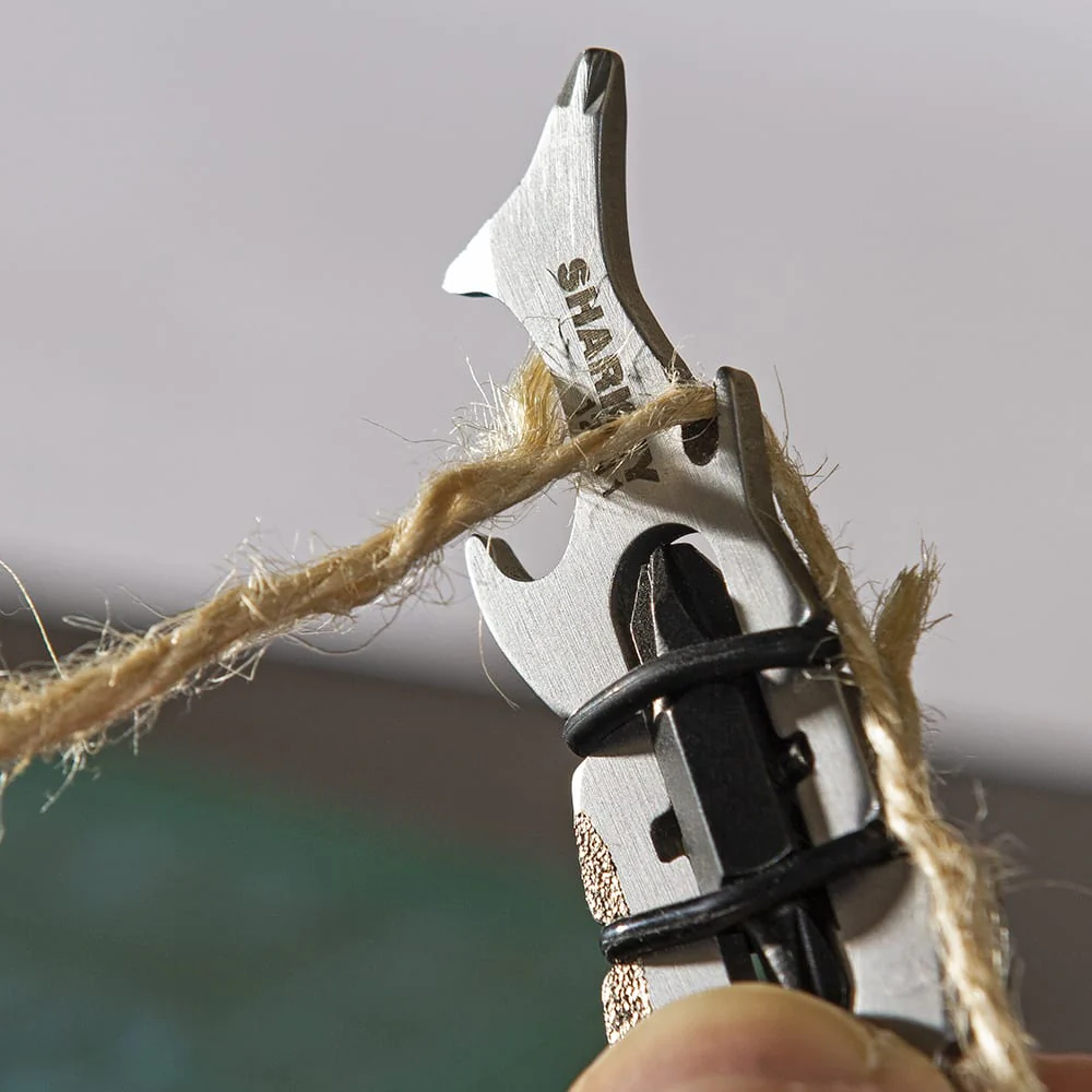 Ein Multitool mit einem Seil darum, mit dem Wort SHARK.
