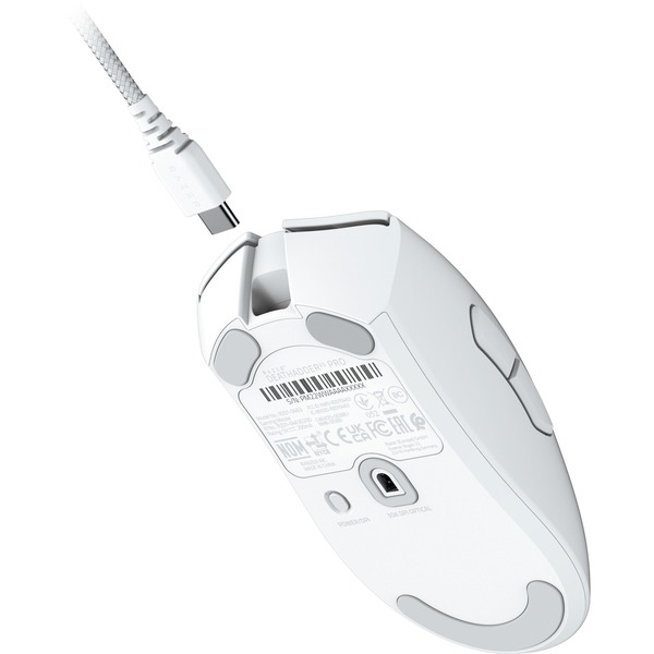 Ratón gaming blanco con cable USB-C conectado. El ratón se ve desde la parte inferior.