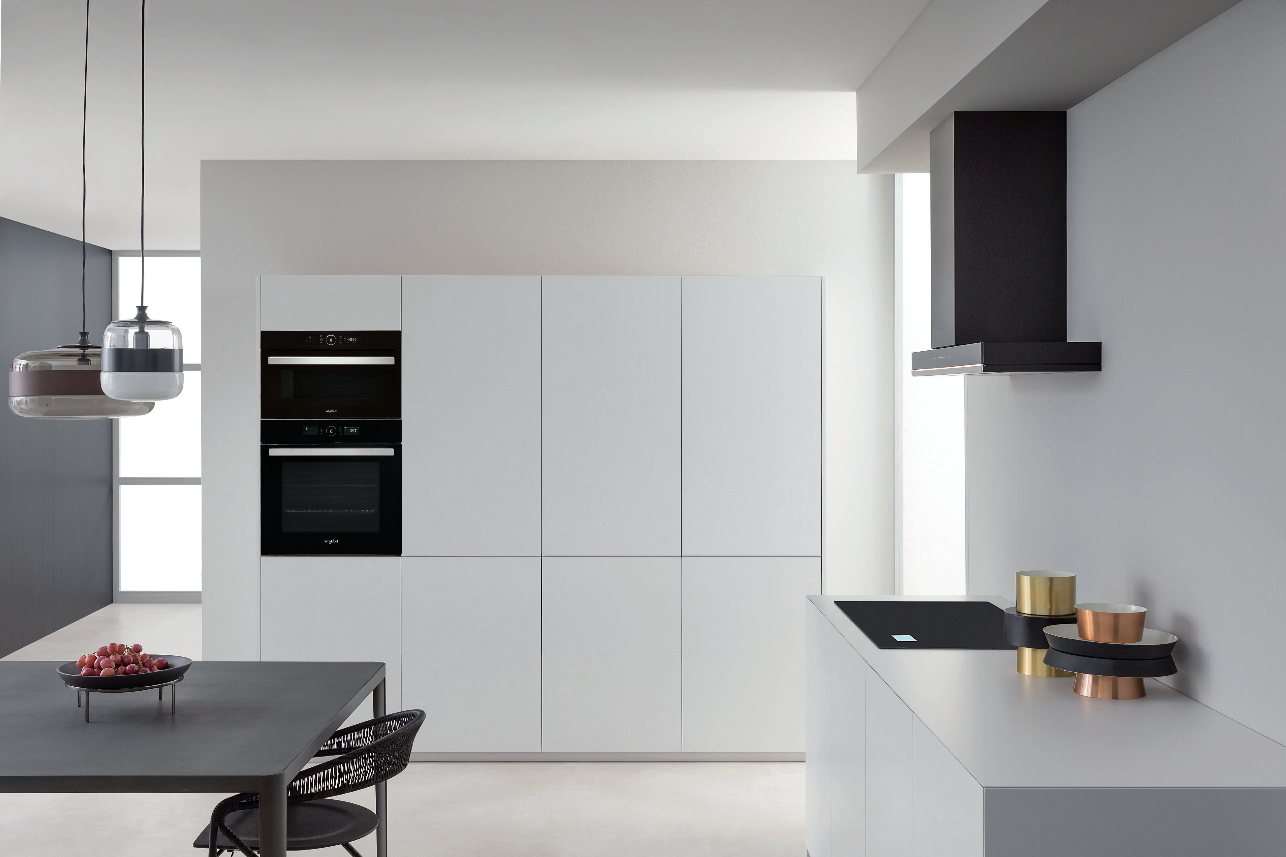 Nowoczesna kuchnia z białymi szafkami i sprzętem AGD.