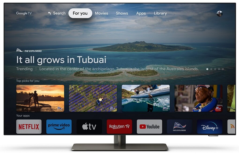 Ekran telewizora wyświetlający interfejs Google TV ze sceną natury i ikonami aplikacji.