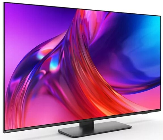 Nowoczesny telewizor na stojaku, czarna ramka, z kolorowym wyświetlaczem pokazującym żywe kolory i gradienty.