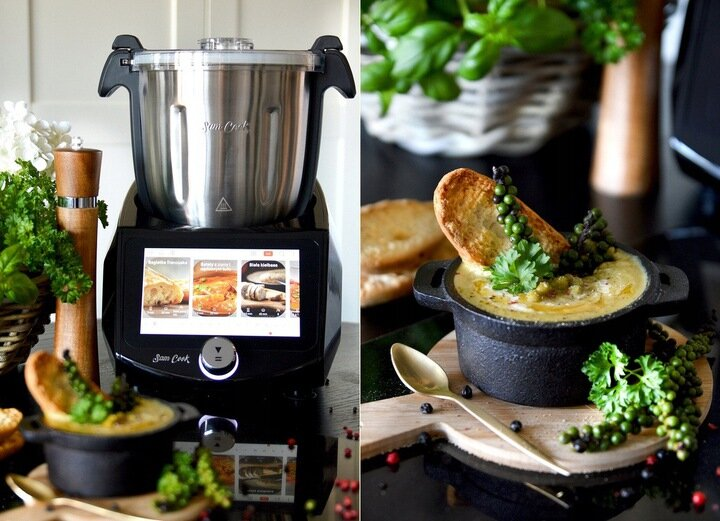 Robot kuchenny z jedzeniem i naczyniami na stole.