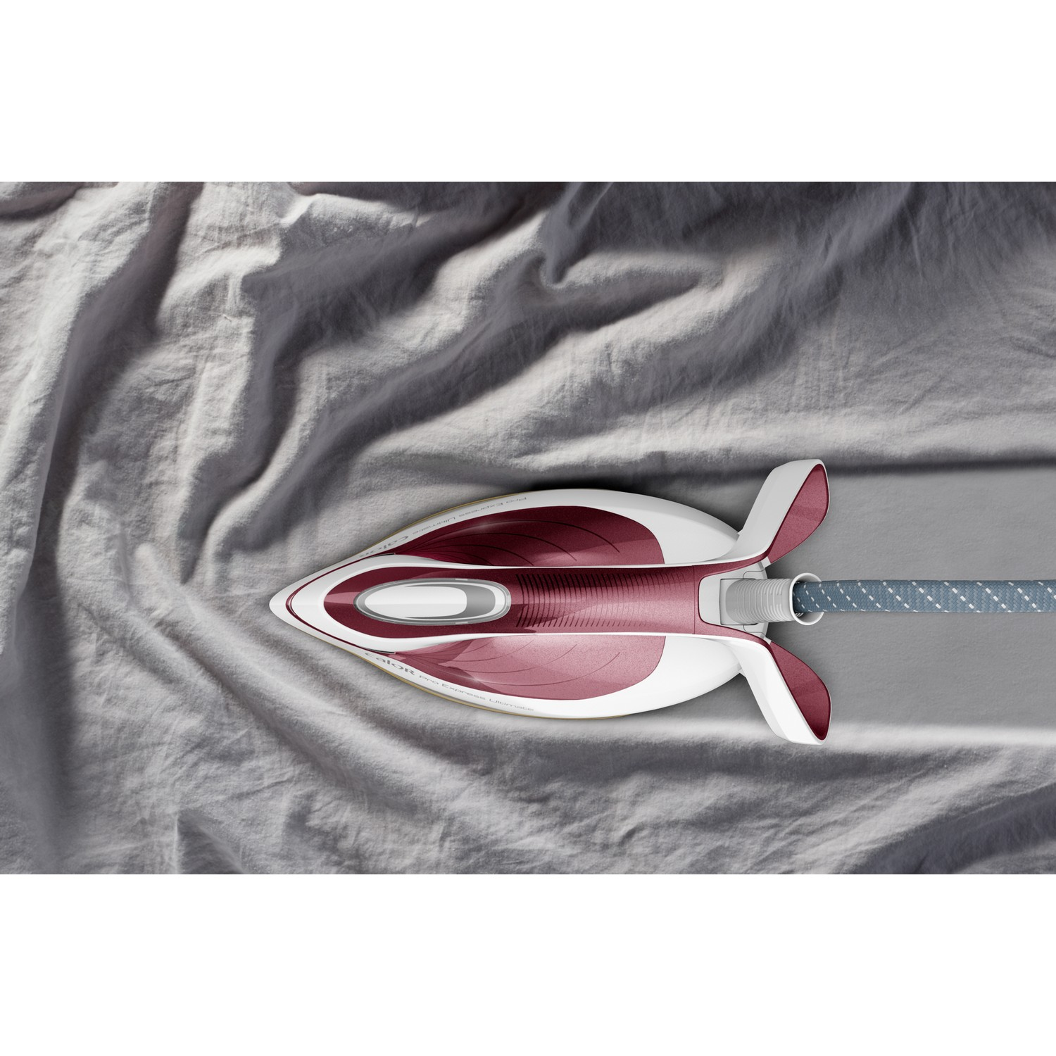 An iron on a grey fabric, with a grey and red color scheme. The cord is visible.