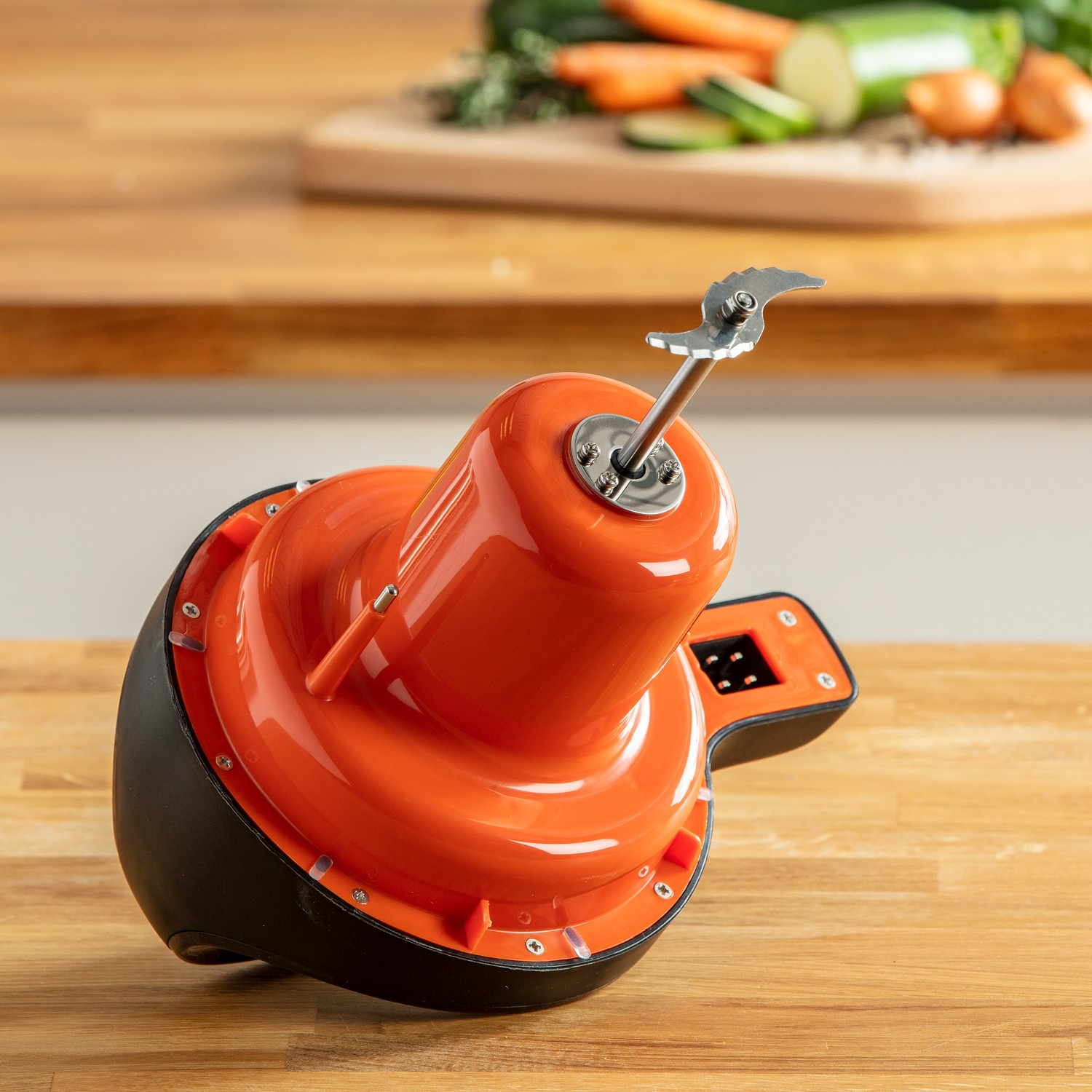 Orange blender on a wooden surface. Black and orange colors.
