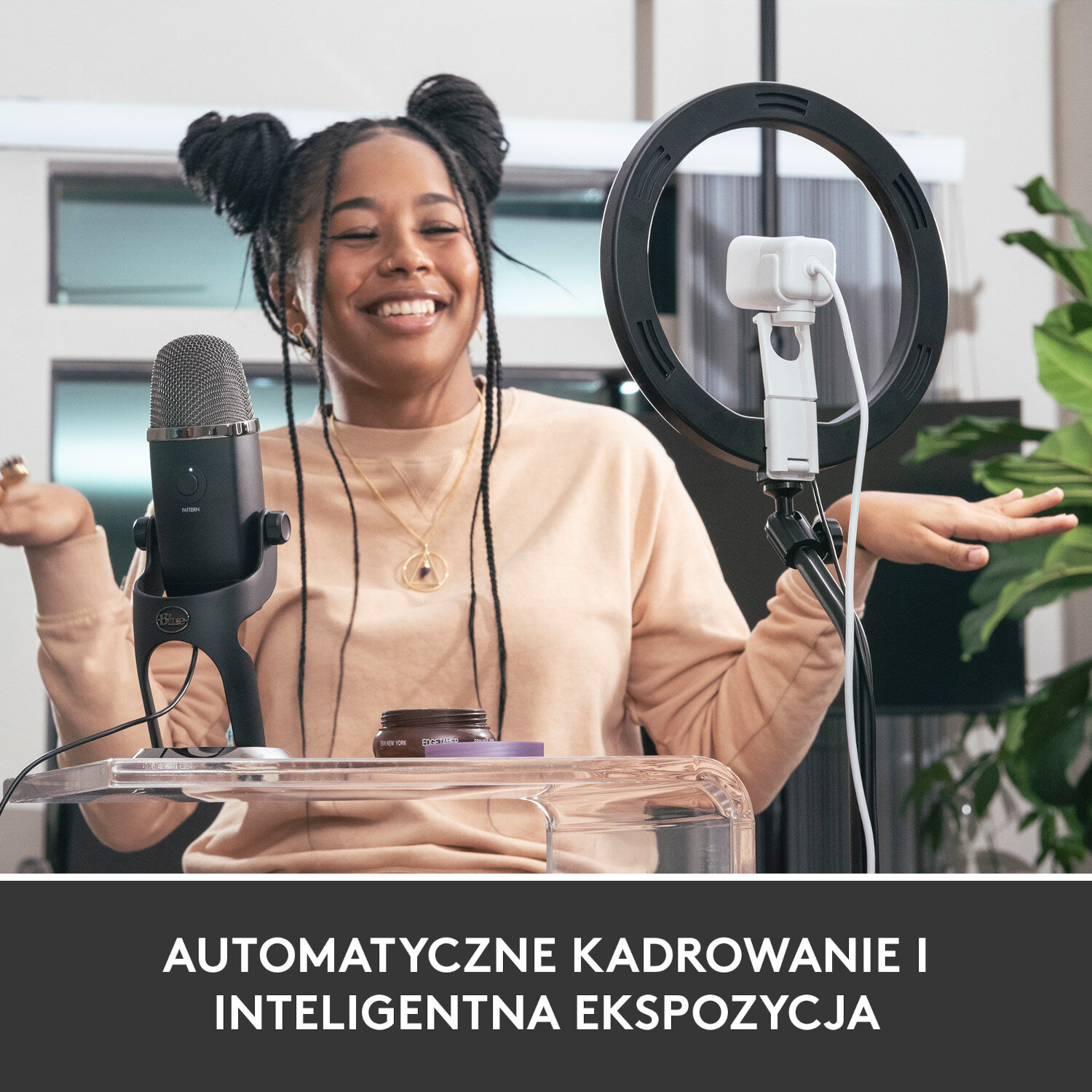 Uśmiechnięta kobieta, używająca mikrofonu i światła pierścieniowego. Przezroczysty stół. Tekst poniżej.