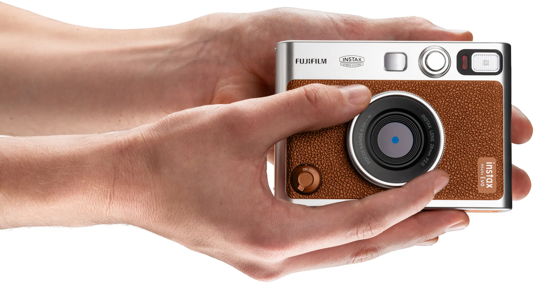Une personne tient un appareil photo Fujifilm Instax. L'appareil est marron et argenté.