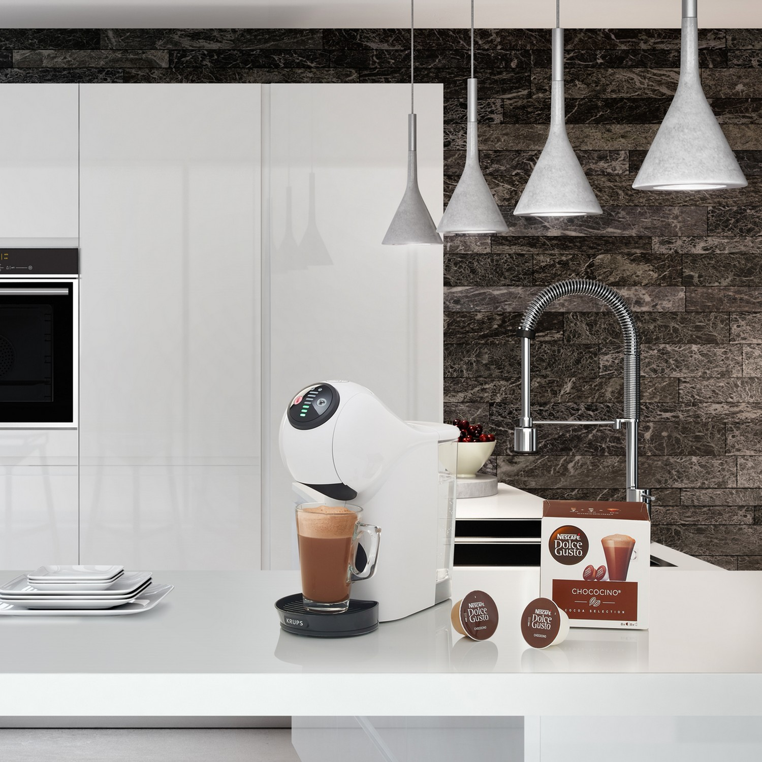 Witte koffiemachine met een kop koffie en capsules op een wit aanrecht.