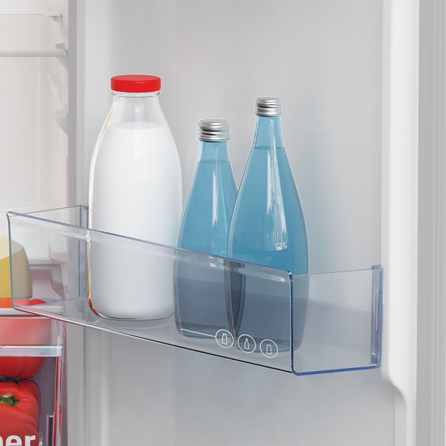 Inside a fridge: milk bottle with red lid, two water bottles, and a shelf. Vegetables are in the bottom.