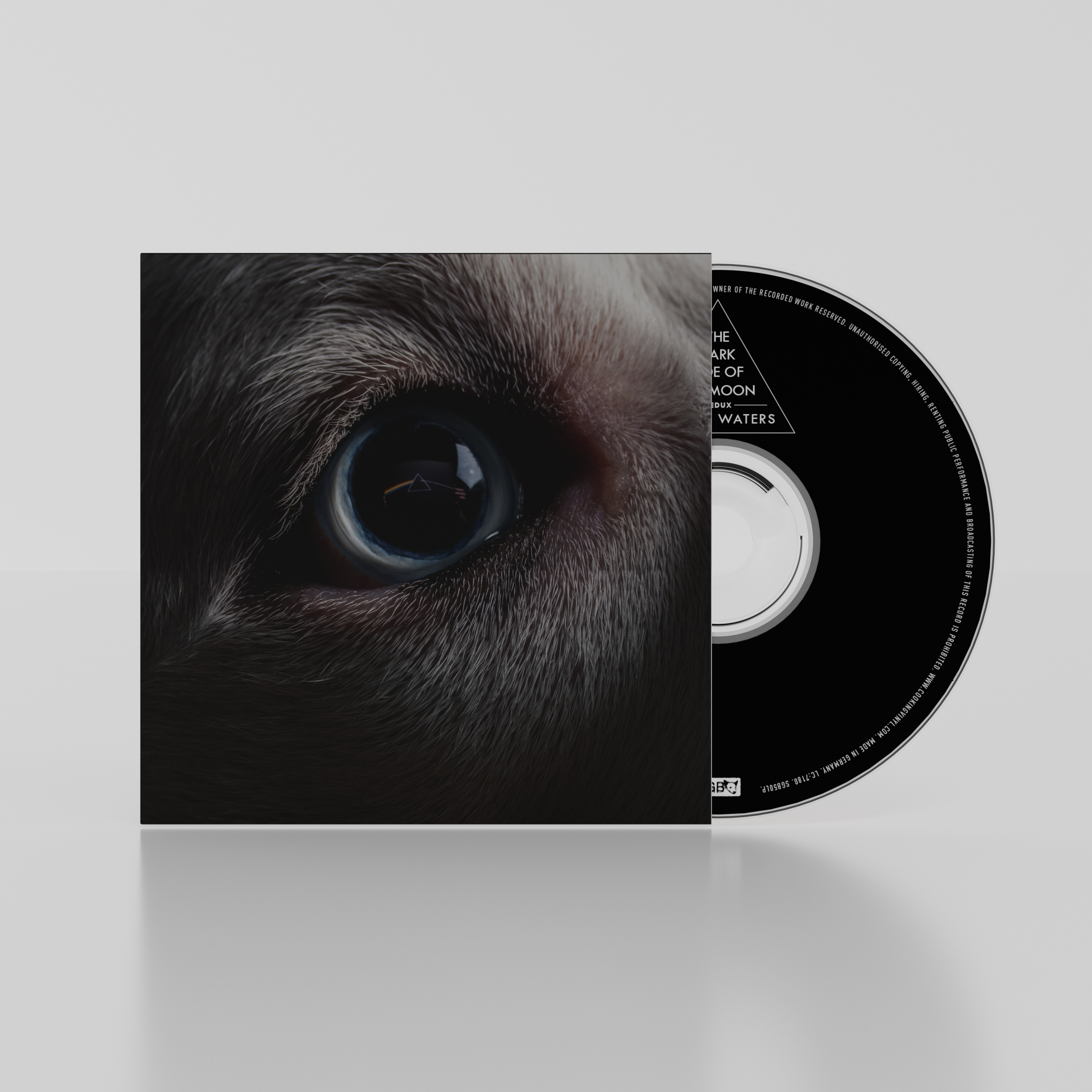 Szem közelképe, kék írisz, sötét szőrzet. CD tok részben látható albumborítóval.