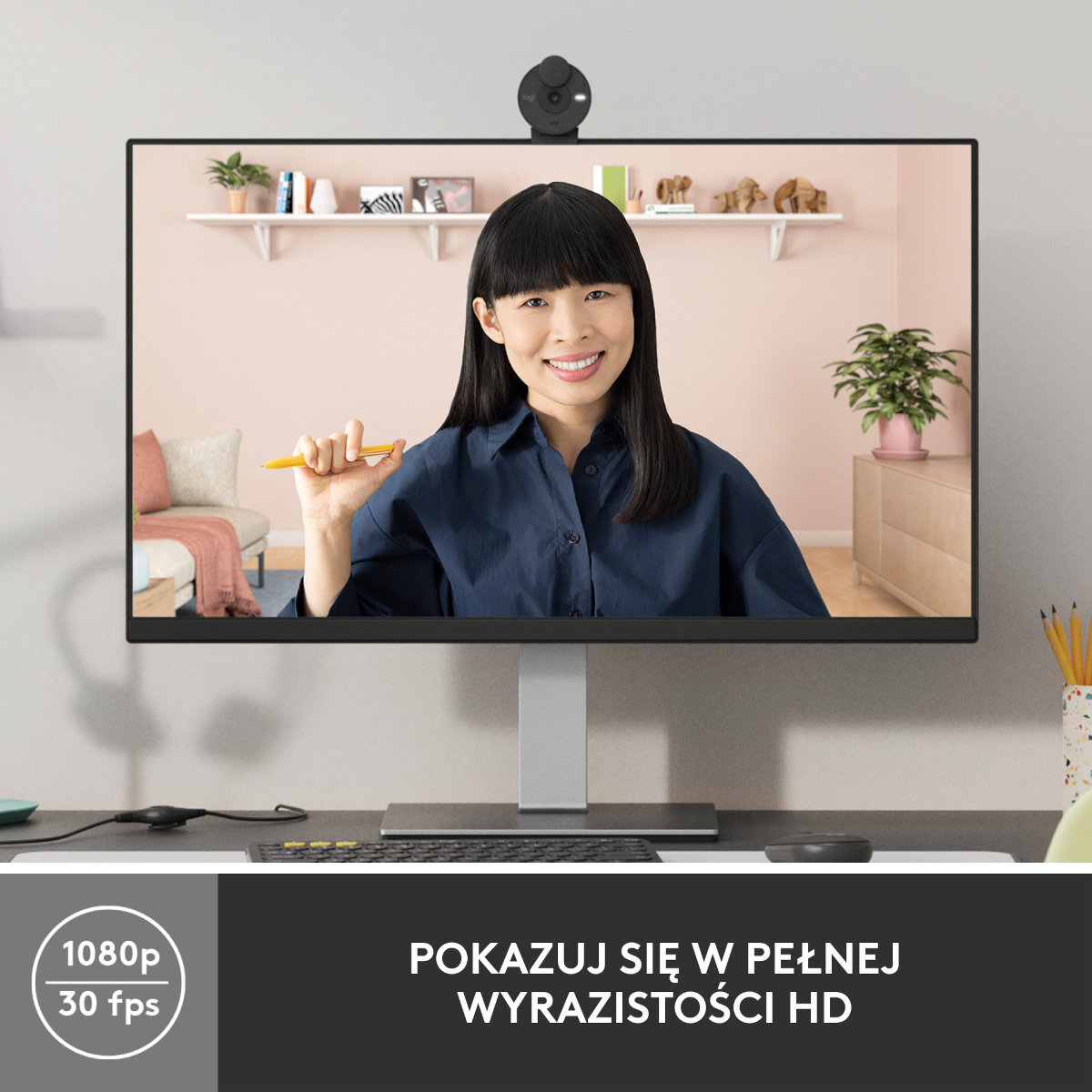 Kobieta na ekranie monitora z podłączoną kamerą internetową. Ekran pokazuje uśmiechniętą kobietę.