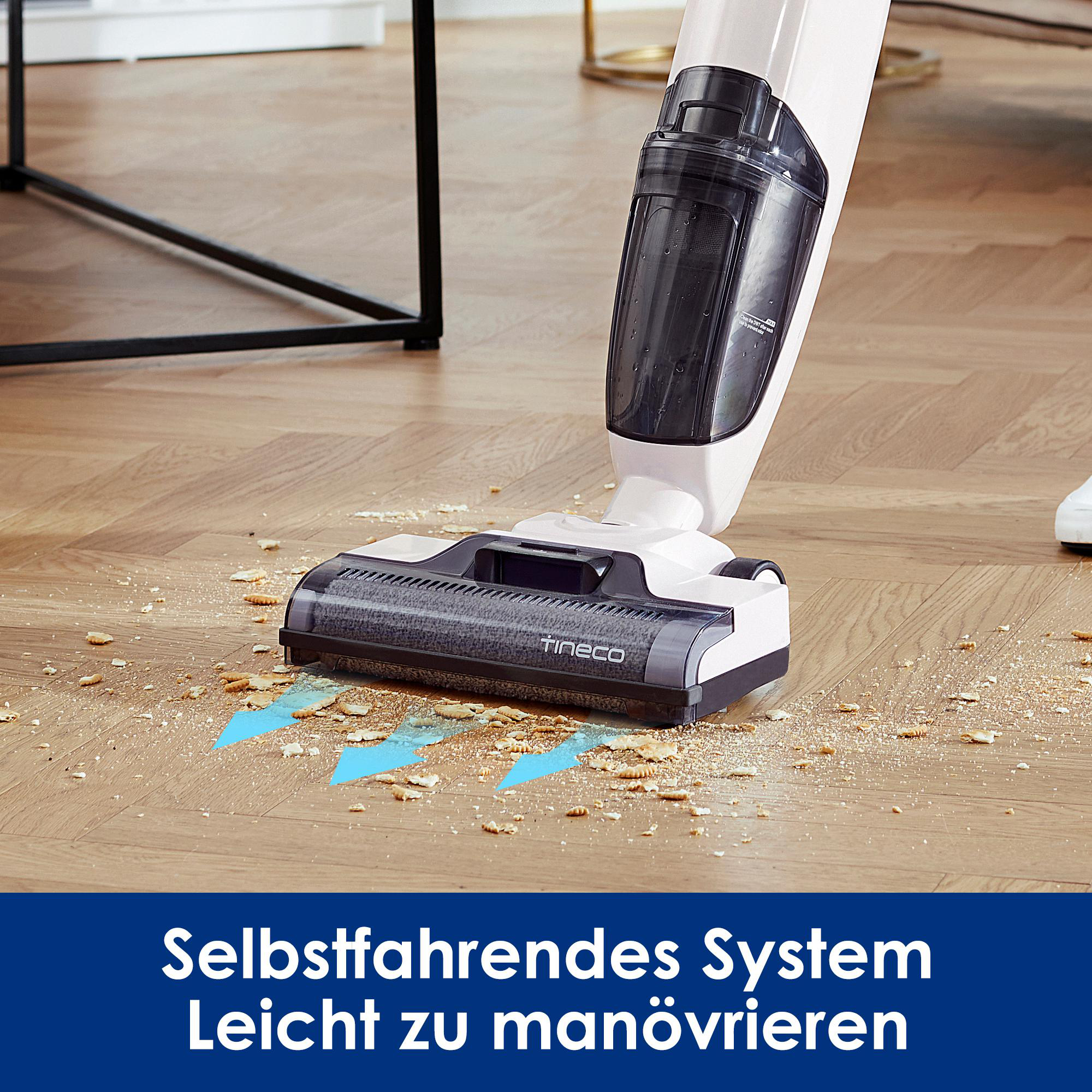 Weißer und schwarzer Staubsauger reinigt Holzboden.