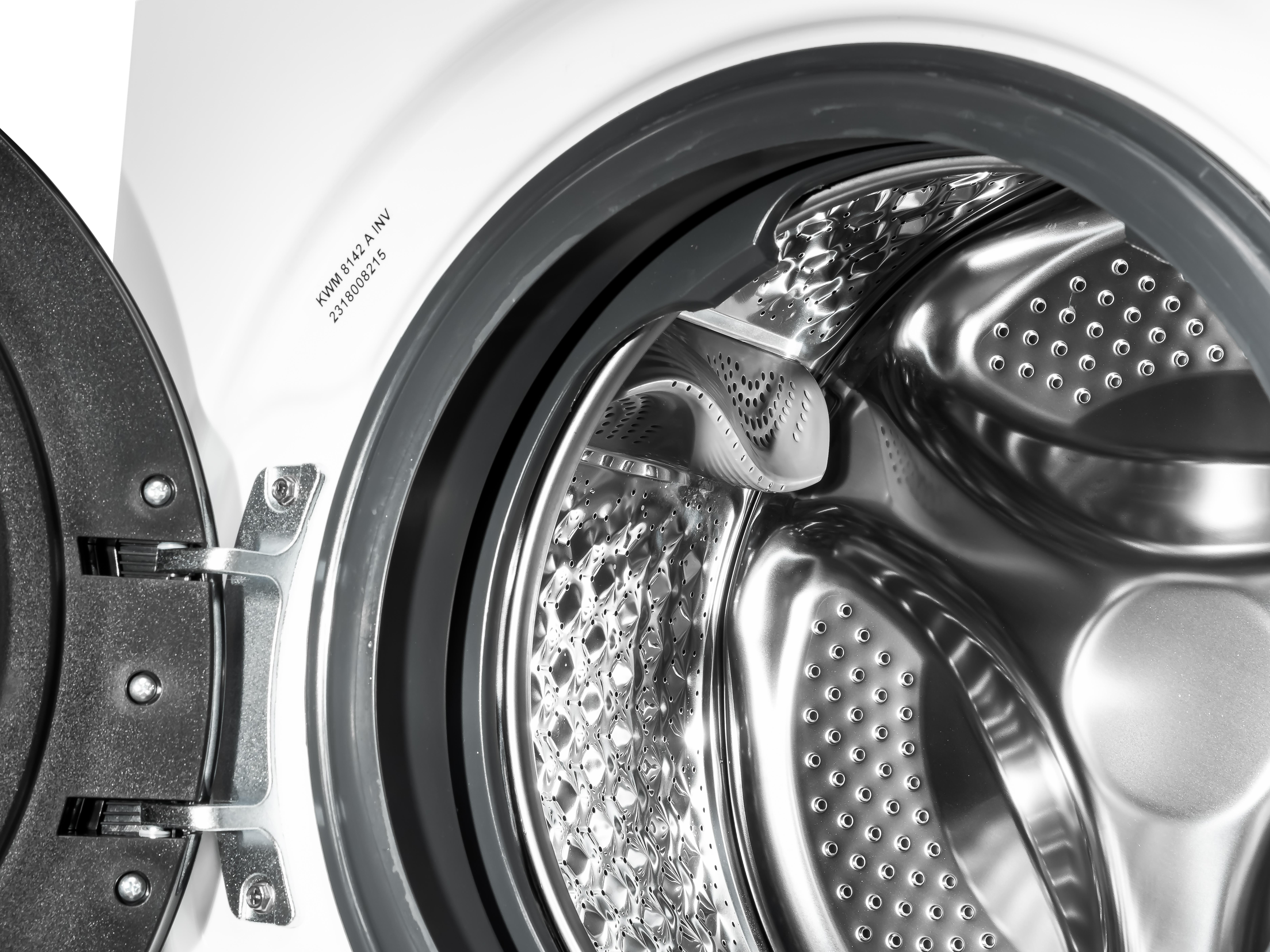 Waschmaschinentrommel innen. Edelstahl-Trommel mit offener Tür, Nahaufnahme.