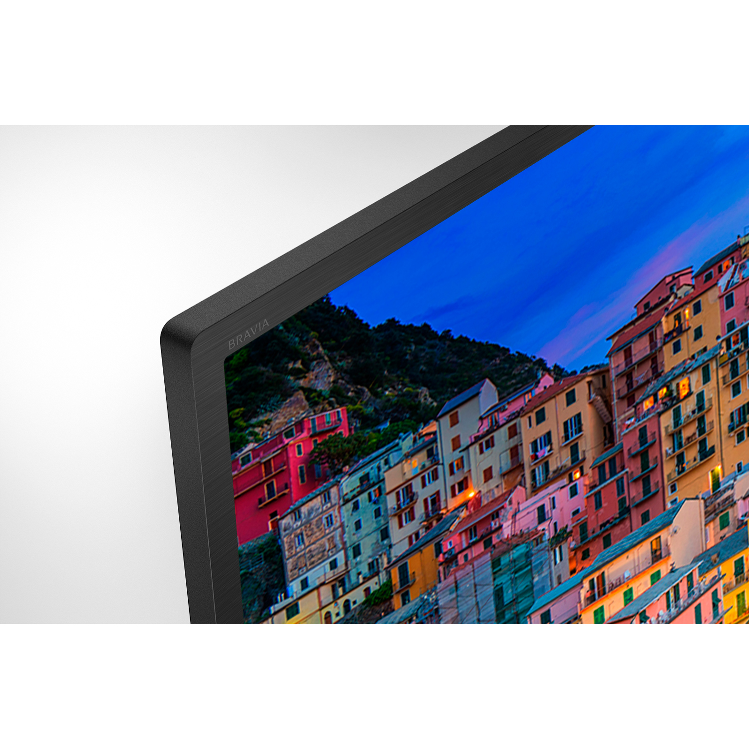Un primo piano di un televisore con un bordo nero. Sullo schermo sono visibili edifici colorati.