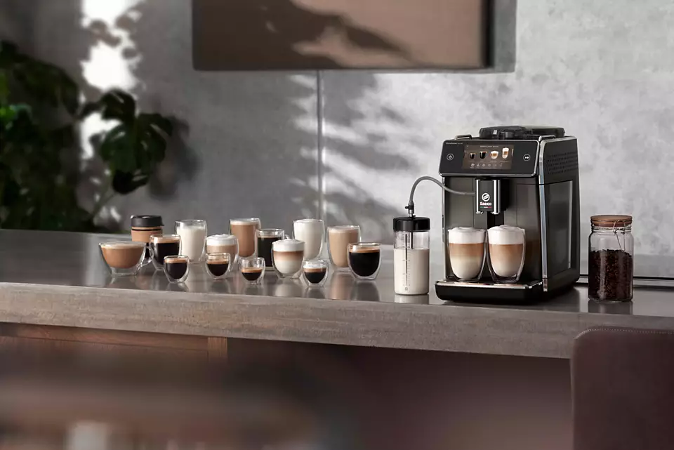 Ekspres do kawy z różnymi napojami kawowymi w szklankach na blacie.