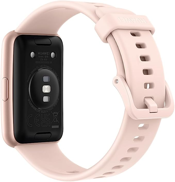 Parte trasera del smartwatch rosa, correa adjunta. Cuadrado negro, texto y etiquetas visibles. Fondo blanco.