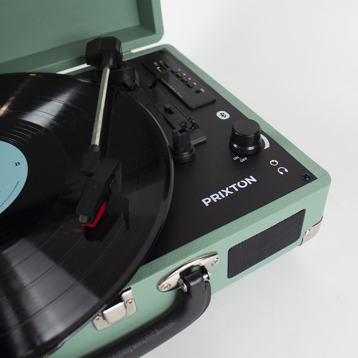 Tocadiscos con un disco de vinilo negro reproduciendo, estuche verde y controles a la derecha.