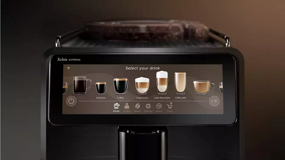 Czarny ekspres do kawy z ekranem dotykowym pokazuje opcje napojów. Jest na ciemnym tle.