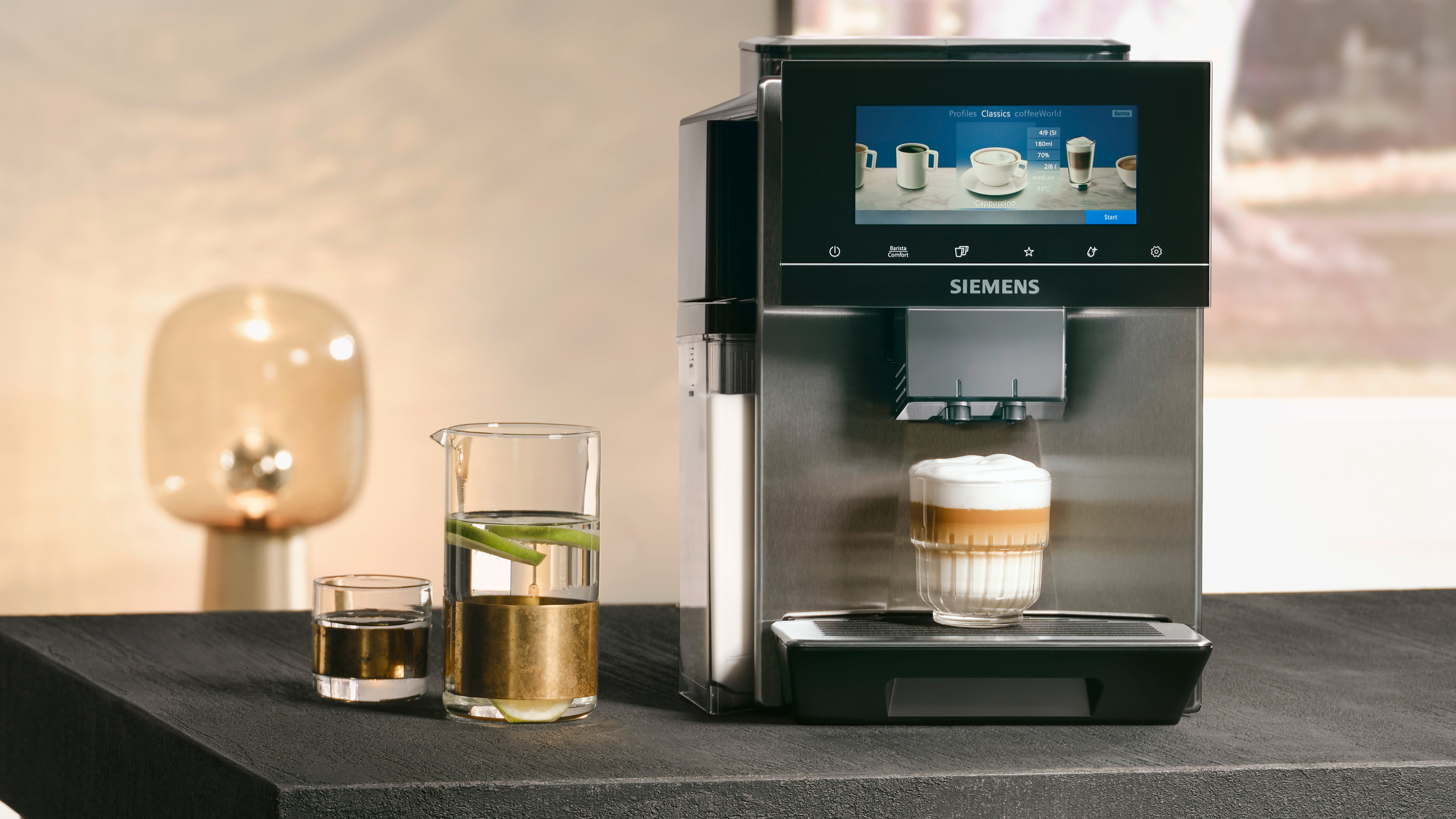 Siemens-Kaffeemaschine, die Latte Macchiato in ein Glas ausgibt, mit einem Wasserglas.