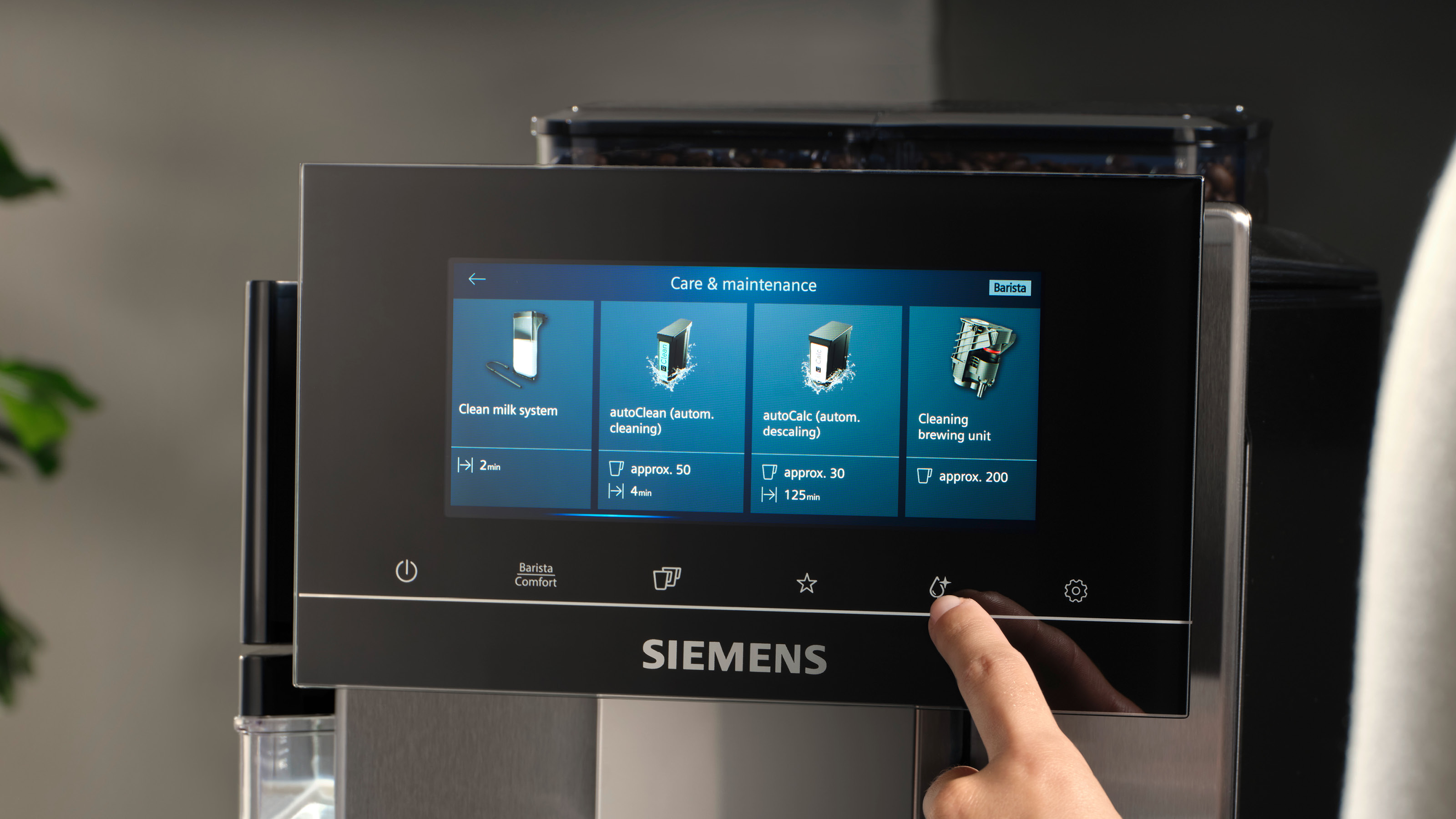 Kaffeemaschinen-Bildschirm mit Pflegeoptionen: Milchsystem reinigen, automatisch reinigen, automatisch entkalken.